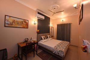 a bedroom with a bed and a desk in a room at Ardas Villa Bikaner - Heritage Luxury Boutique Stay, With Free Pick Up and Drop in Bikaner