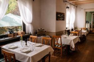 a restaurant with tables and chairs with white tablecloths at Holzschuhs Schwarzwaldhotel und Restaurant in Baiersbronn