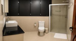 a bathroom with a toilet and a sink and a shower at Hotel Residence in Caruaru