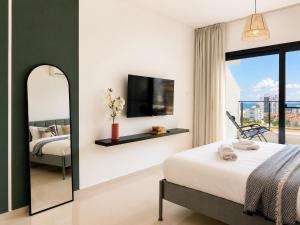 a bedroom with a bed and a tv and a mirror at Caesar Resort & Spa Collection Studios Pools & Long Beach in Iskele +54 photos