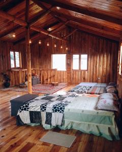 ein Schlafzimmer mit einem großen Bett in einer Holzhütte in der Unterkunft Agape Log Cabin in Sagada