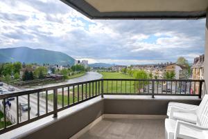 a balcony with white chairs and a view of a street at Regency Aparthotel Sarajevo in Sarajevo