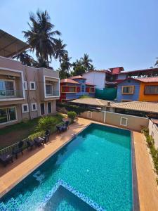 a large swimming pool in front of a building at Fortune Resort in Alībāg