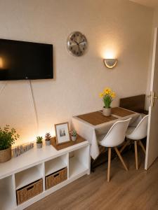a living room with a table and a clock on the wall at Alpine Studio near Bad Ischl#2 in Haiden +16 photos