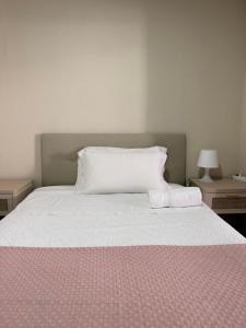 a bed with two pillows on it with two tables at Apartamento Kalea Dany in Vitoria-Gasteiz +1 photo