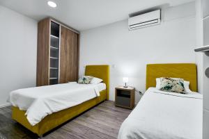 a bedroom with two beds and a night stand at Regency Aparthotel Sarajevo in Sarajevo