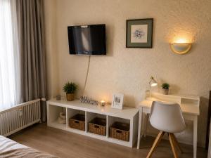a room with a desk and a tv on a wall at Alpine Studio near Bad Ischl#2 in Haiden