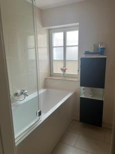 a bathroom with a bath tub and a window at Das Gäste Haus in Dresden