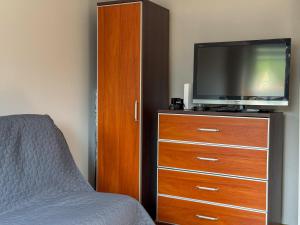 a bedroom with a tv and a dresser with a bed at 11 smart by LibertaRent in Wałbrzych