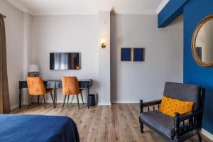 a bedroom with a bed and a desk and chairs at Lill Maison Hotel & City Club in Fethiye