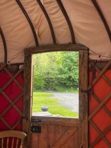 a window in a yurt with a view of a yard at Hillside Retreats in Machynlleth