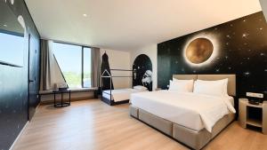 a bedroom with a large bed with a moon mural at OS Style Hotel Batam Centre in Batam Center +24 photos