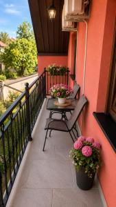 a patio with a table and flowers on a balcony at Honey House Martinovic in Cetinje