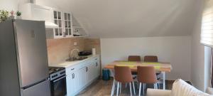 a kitchen with a table and chairs and a refrigerator at Honey House Martinovic in Cetinje