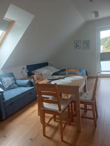 a living room with a table and chairs and a couch at APARTAMENTY BAŁTYCKA 4d in Rowy