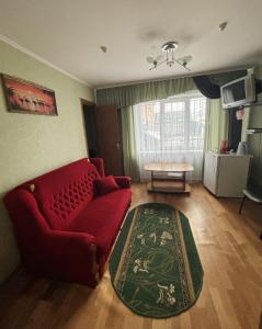 a living room with a red couch and a table at готель Славутчанка in Slavuta