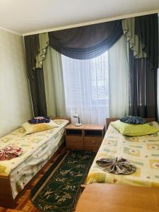 a bedroom with two beds and a window at готель Славутчанка in Slavuta +5 photos