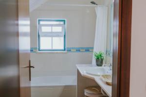 a white bathroom with a sink and a shower at Casa do Mar - Almograve - Magnífico terraço com vista para o campo in Almograve