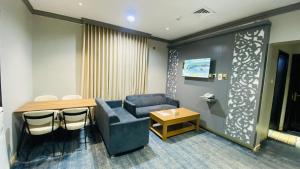 a waiting room with a blue chair and a table at Al Raiyan Serviced Apartments in Taif