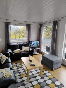 a living room with a couch and a coffee table at Havblikk, cozy cabin by the sea with beautiful views in Mandal