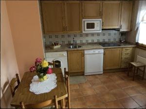 a kitchen with a table with a vase of flowers on it at Casa Nansi in Berodia +4 photos