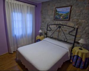 a bedroom with a bed and a stone wall at Casa Nansi in Berodia