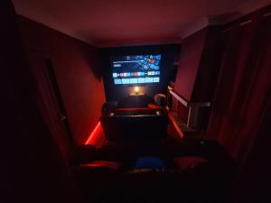 a dark room with a chair and a television at Villa Nevada - Espacioso Chalet con Piscina Privada y Salita de Cine in Port de Pollensa