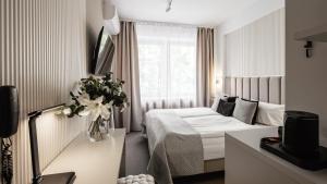 a hotel room with a bed and a vase of flowers at Hotel Delta in Krakow