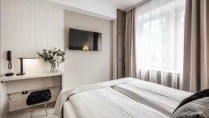 a bedroom with a bed and a tv on the wall at Hotel Delta in Krakow