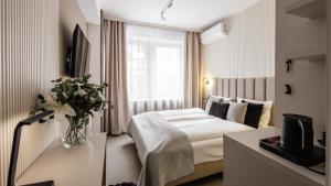 a hotel room with a bed and a vase of flowers at Hotel Delta in Krakow