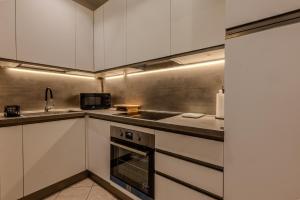 a kitchen with white cabinets and a sink at Deluxe Flat Empoli GVARO in Empoli