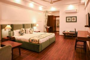 a hotel room with a bed and a desk at Hotel Samrat - A Boutique Hotel in Prayagraj
