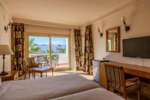 a hotel room with a bed and a flat screen tv at Continental Plaza Beach Resort in Sharm El Sheikh