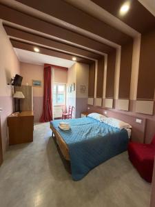 a bedroom with a large bed and a red chair at Do Carioca in Villalvernia
