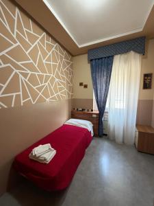 a bedroom with a bed with a red bedspread at Do Carioca in Villalvernia