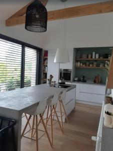a kitchen with a large island with bar stools at Maison centre-ville, Vue château, Hellfest, Clisson in Clisson