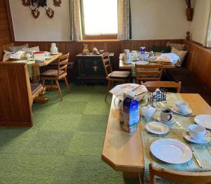 a dining room with tables and chairs with dishes on them at Landhaus Aigner in Mittersill