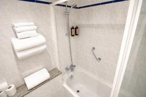 a bathroom with a shower and a bath tub with towels at Lakeside Manor Hotel in Virginia