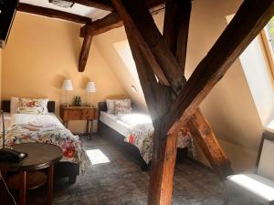 a attic bedroom with two beds and a table at Pałac Łagów - Hotel in Zgorzelec