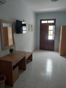 an empty room with a door and a large room with a desk at PHILIPPOS STUDIOS & APT in Lindos