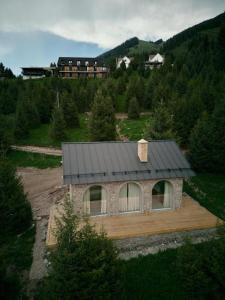 a house with a black roof on top of a field at Pana Unique Kolsay in Kurmenty