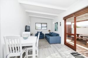 a living room with a table and a blue couch at Owlet Cottage in Arniston in Arniston +17 photos