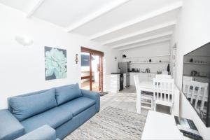 a living room with a blue couch and a kitchen at Owlet Cottage in Arniston in Arniston