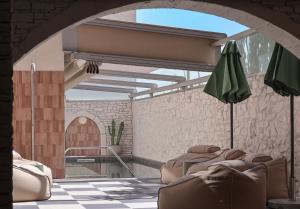 a room with a patio with a table and an umbrella at Mistral Bay Hotel in Agios Nikolaos