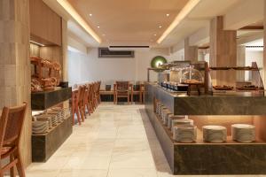 a restaurant with a counter with plates on it at Mistral Bay Hotel in Agios Nikolaos