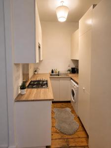 a kitchen with white cabinets and a stove top oven at Comfortable 2 Bedroom Flat in Leith in Edinburgh +3 photos