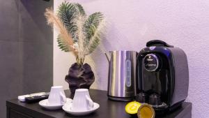 a coffee maker on a table with a vase of wheat at Aetna LuxurySuites in Catania