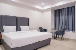 a bedroom with a bed and a table and chairs at Chhapaak Resort in Patna