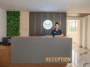 a woman is standing behind a reception desk at Chhapaak Resort in Patna