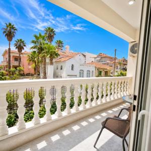 a balcony with a white fence and palm trees at Sunset Apartments in Missolonghi